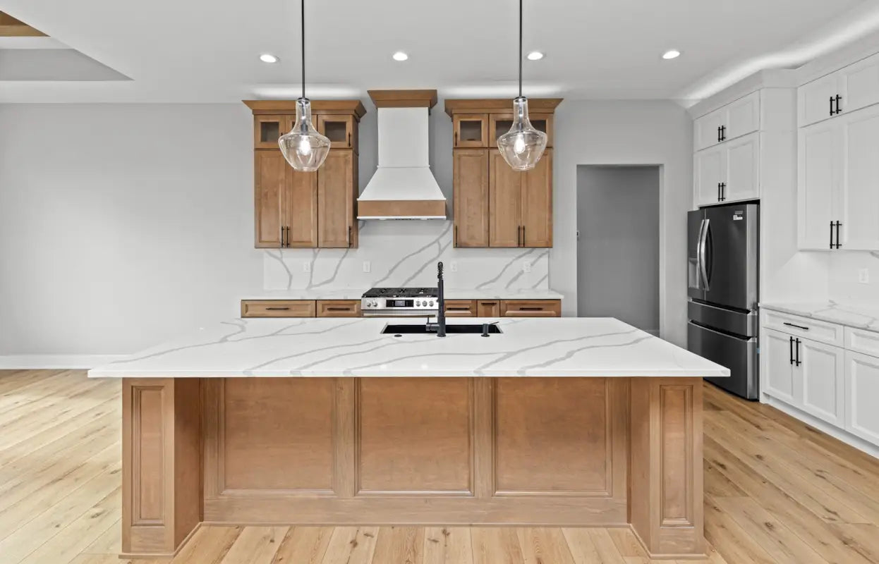 Modern kitchen with wooden island, white countertops, and stainless steel appliances.