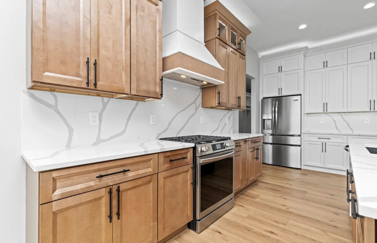 Modern kitchen with Oxford Toffee wooden cabinets, stainless steel appliances, and white countertops.