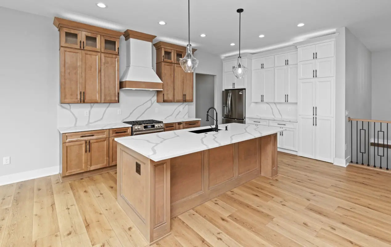 Modern kitchen with wooden cabinets, marble countertops, and stainless steel appliances.
